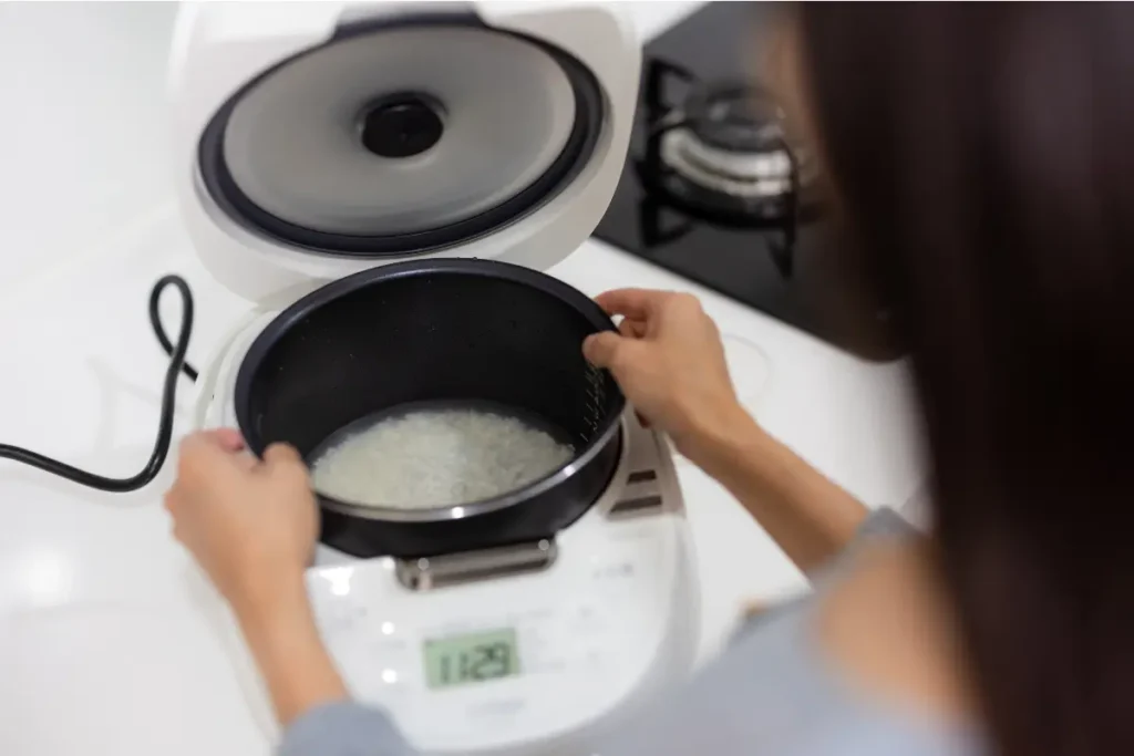 Menanak nasi Seorang wanita sedang menanak nasi putih