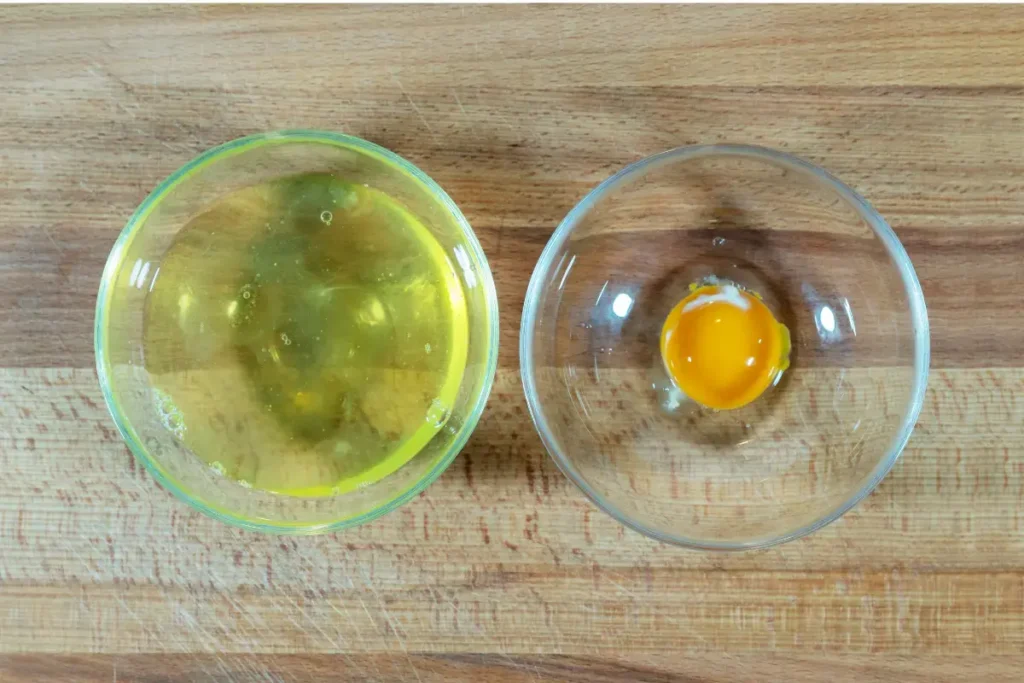 Putih Telur atau Telur Utuh? Ini yang Lebih Efektif untuk Massa Otot Gambar putih telur dan kuning telur mentah yang dipisahkan